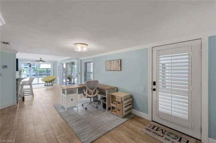 Office area featuring light wood finished floors, ornamental molding, and ceiling fan