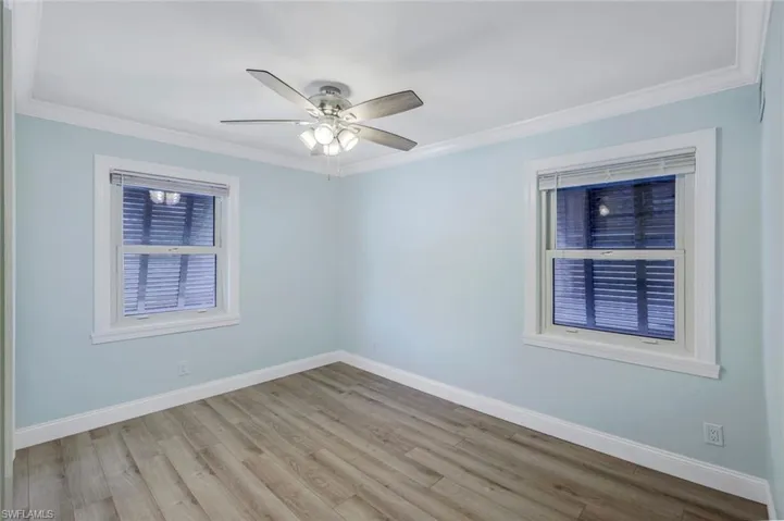 Spare room with ornamental molding, wood finished floors, and ceiling fan