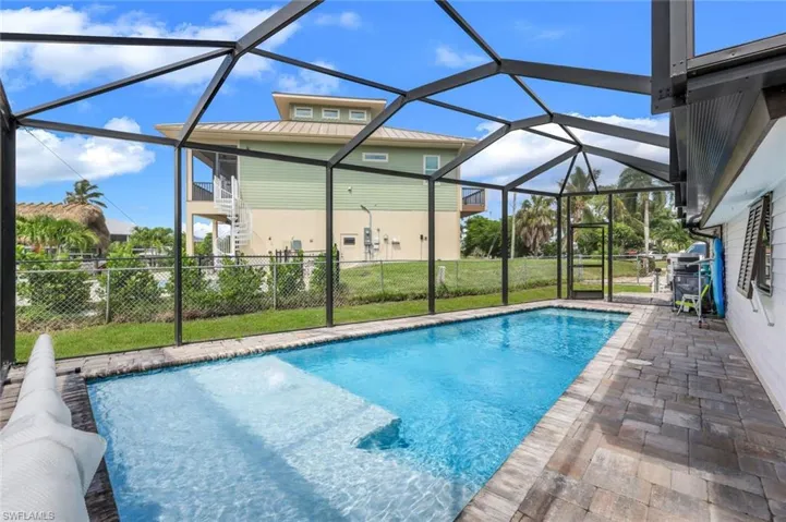 View of swimming pool with a sunroom, a patio area, a lanai, and a lawn