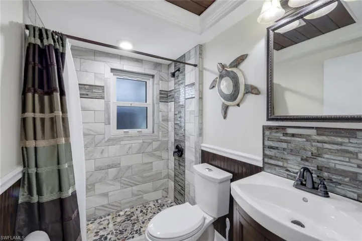 Bathroom with wainscoting, vanity, and a shower stall