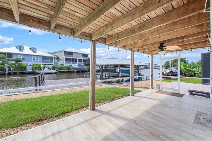 View of patio with a dock, a water view, and boat lift