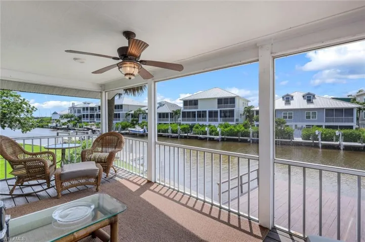 Sunroom featuring a water view and a residential view