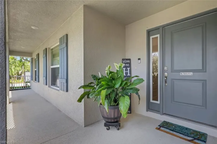 Covered front entry featuring a gray paneled door with a sidelight, recessed lighting, and textured exterior walls
