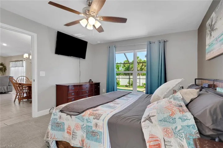 Spacious bedroom featuring light gray walls and plush gray carpeting