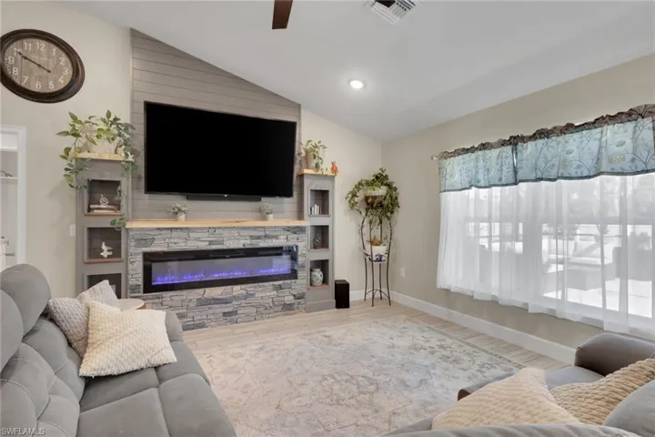 Living area featuring a custom media wall with stacked stone facade and an integrated electric fireplace