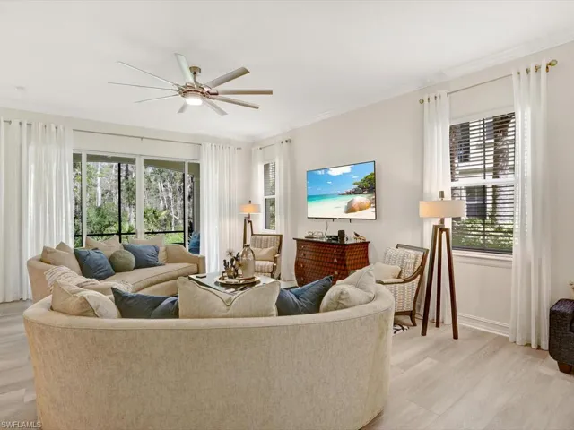 Living area featuring light wood-type flooring, ceiling fan, and ornamental molding