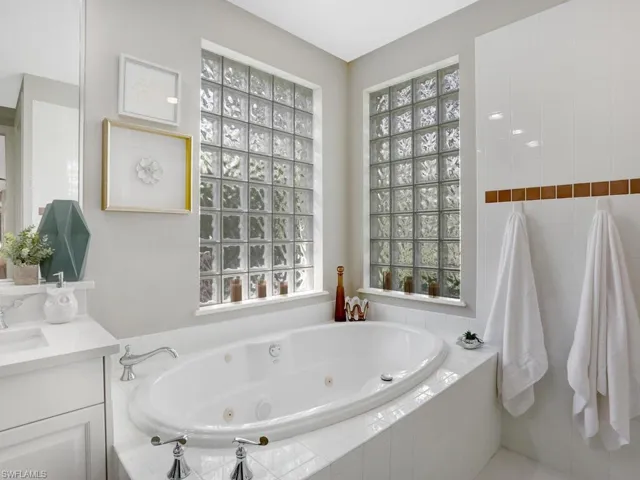 Bathroom with vanity, plenty of natural light, and a whirlpool tub