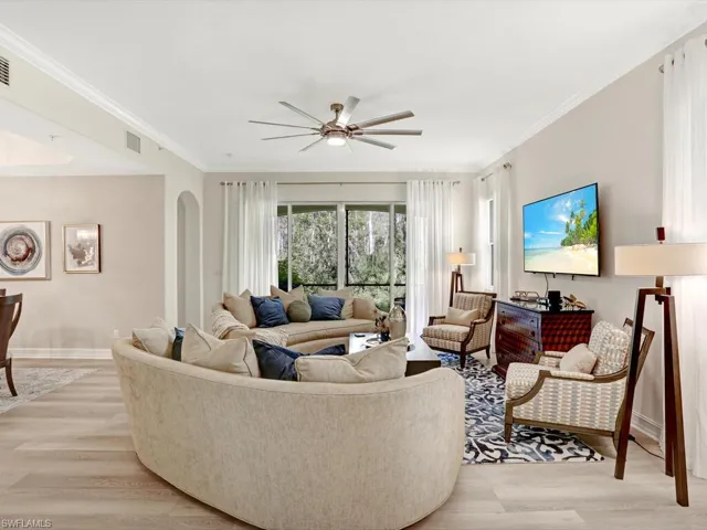 Living area with light wood-type flooring, crown molding, and a ceiling fan