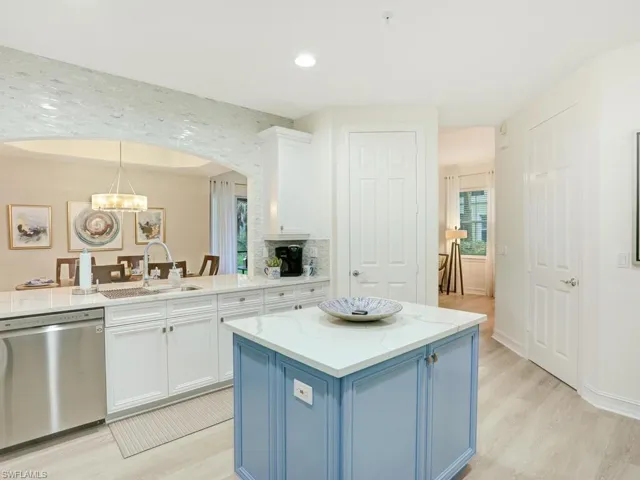 Kitchen featuring blue cabinetry, dishwasher, white cabinets, light stone countertops, and recessed lighting