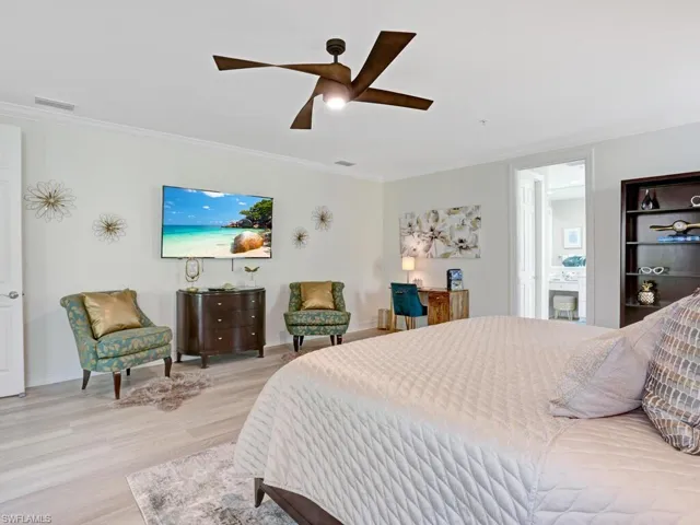 Bedroom with crown molding, wood finished floors, and ceiling fan