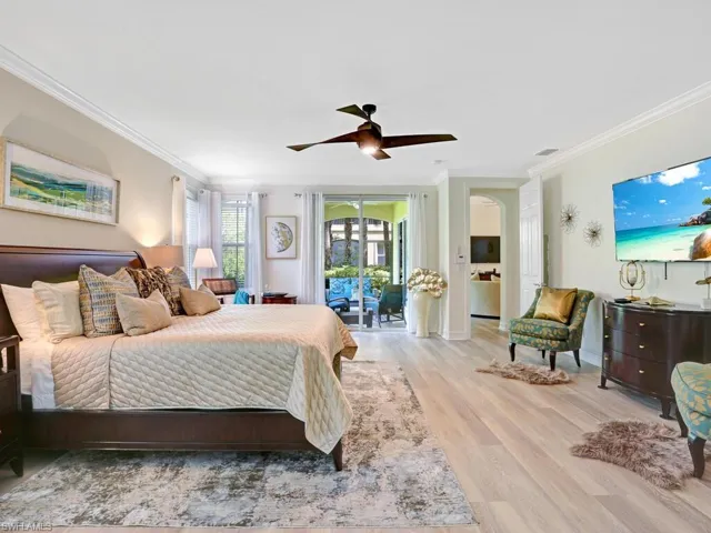 Bedroom with light wood-style floors, ornamental molding, a ceiling fan, and access to exterior