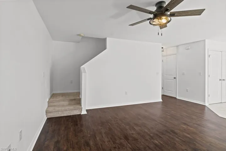 Unfurnished living room featuring dark wood finished floors and ceiling fan