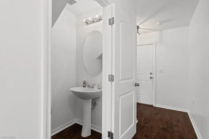 Bathroom featuring dark wood-style flooring and baseboards