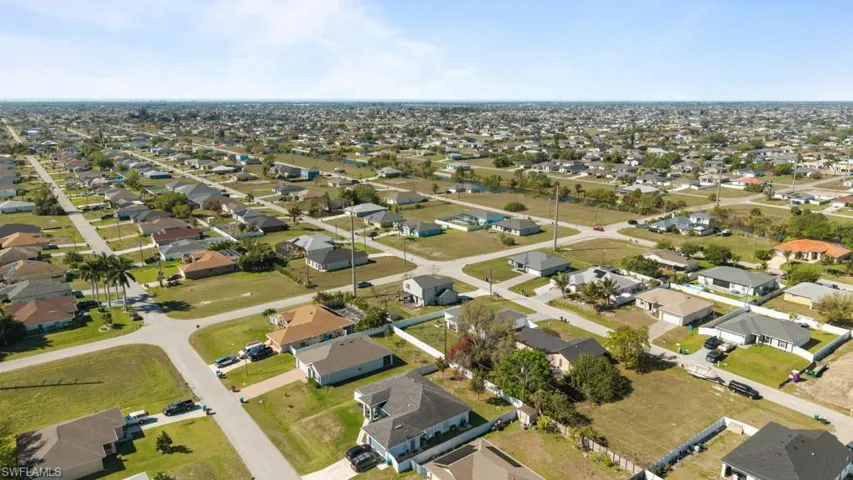 Aerial view of property and surrounding area with nearby suburban area