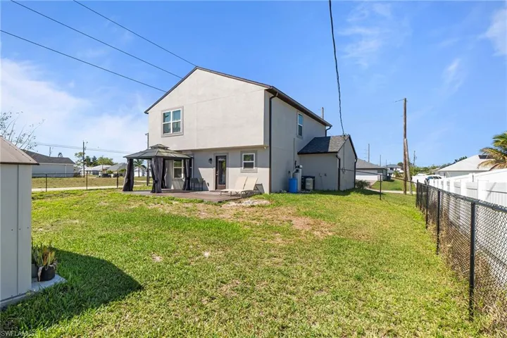 Back of house with stucco siding, a gazebo, a patio, and a fenced backyard