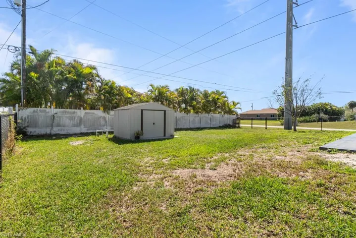 Fenced backyard featuring a storage shed