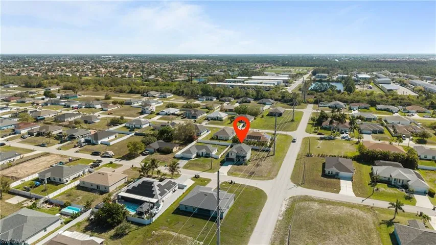 Aerial view of property and surrounding area with nearby suburban area
