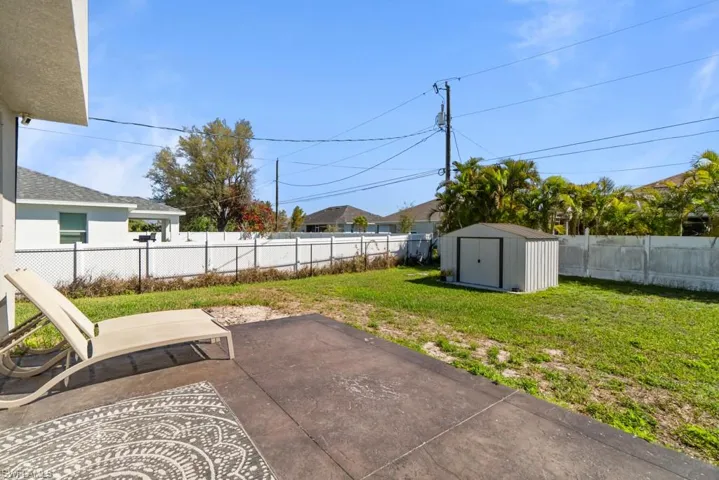 Fenced backyard with a shed and a patio