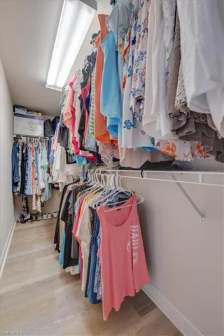 Walk in closet with wood finished floors