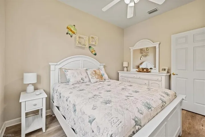 Bedroom featuring visible vents, ceiling fan, baseboards, and wood finished floors