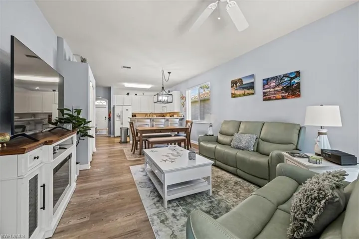Living area with visible vents, light wood-style floors, and a ceiling fan