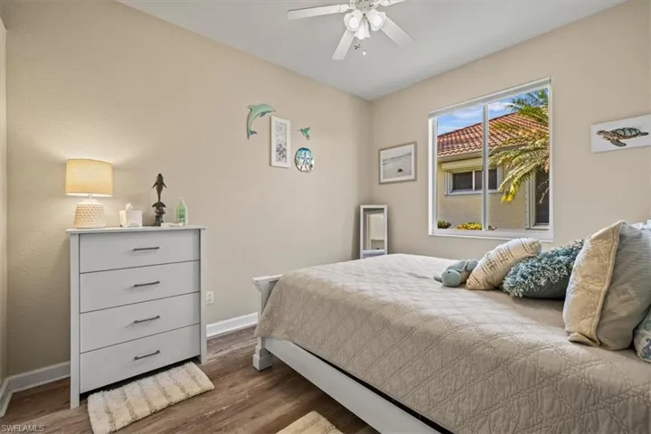 Bedroom with baseboards, ceiling fan, and dark wood-style flooring