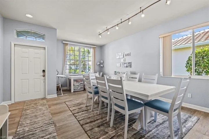 Dining room with visible vents, track lighting, baseboards, and wood finished floors