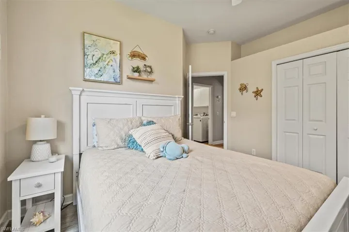 Bedroom featuring a closet, washer / clothes dryer, baseboards, and wood finished floors