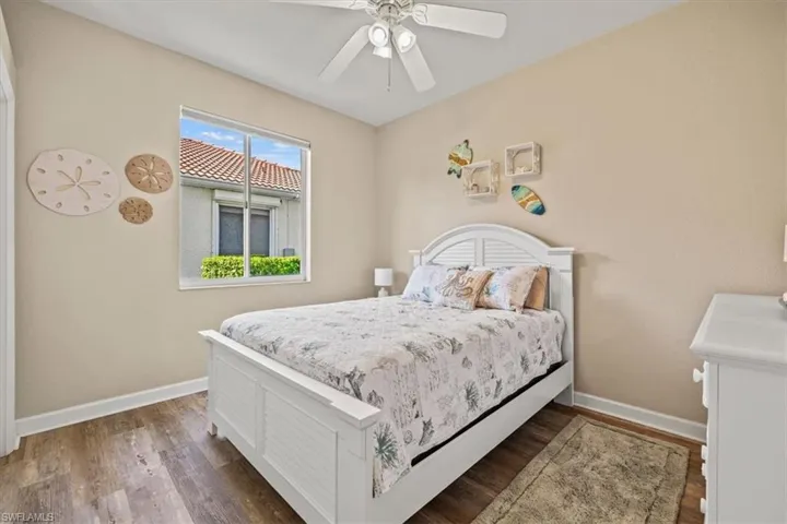 Bedroom featuring baseboards, dark wood finished floors, and a ceiling fan