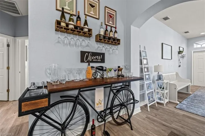 Kitchen featuring white appliances, a sink, decorative backsplash, white cabinets, and light wood-style floors