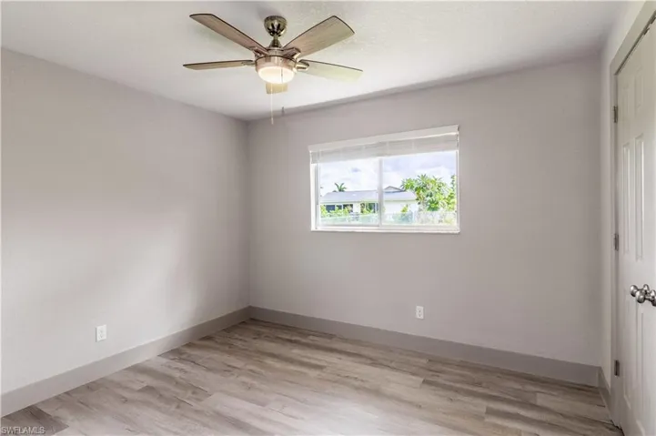 Unfurnished bedroom with ceiling fan and light hardwood / wood-style flooring