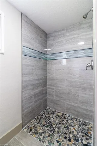 Bathroom with a tile shower and a textured ceiling