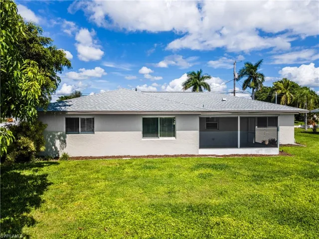Back of property with a patio area, a sunroom, and a lawn