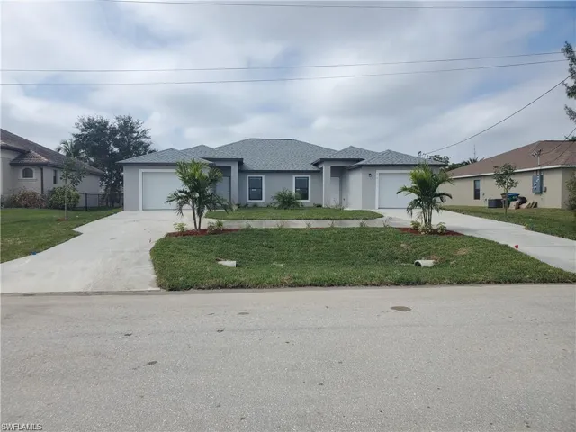 View of front of home featuring a garage, driveway, and a front yard