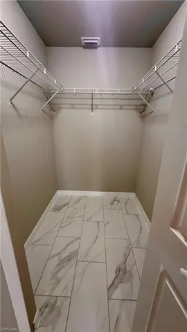 Walk in closet with marble finish flooring