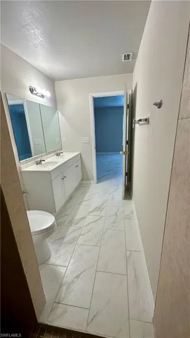 Bathroom featuring marble finish flooring and double vanity