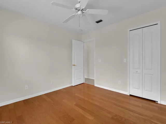 Room featuring wood-finish flooring, white baseboards, and neutral wall tones