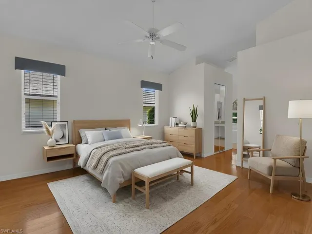 Spacious room featuring vaulted ceilings, wood-finish flooring, and white walls