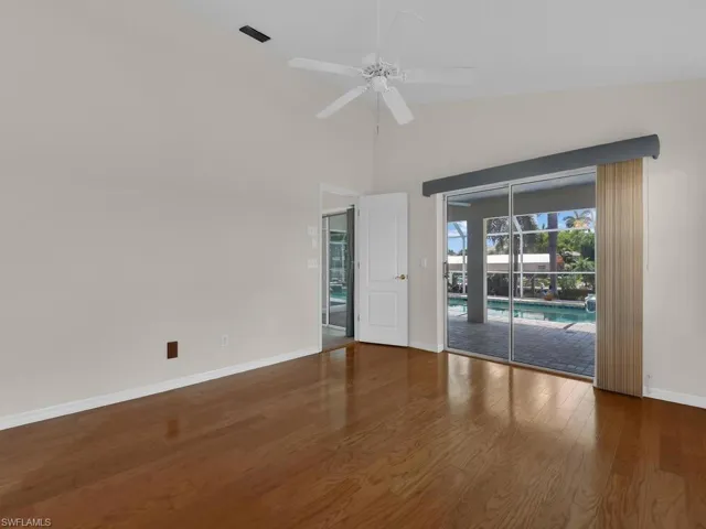 Room featuring wood-finish flooring, vaulted ceiling, and a ceiling fan