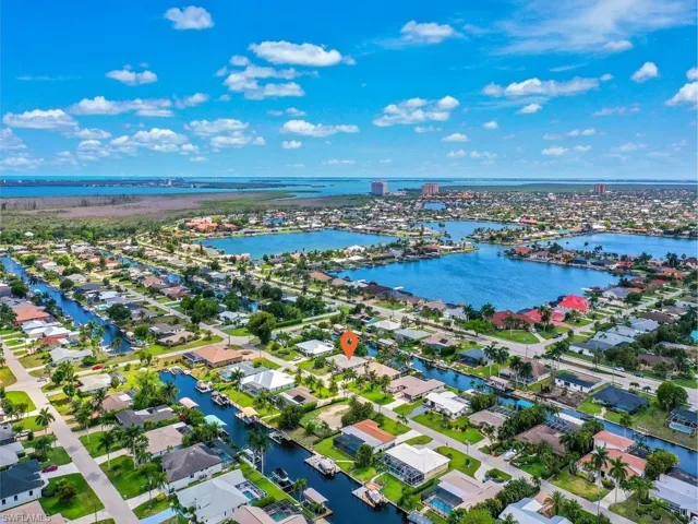 Aerial perspective showcasing a residential area with extensive canal frontage, numerous homes, and open water expanses
