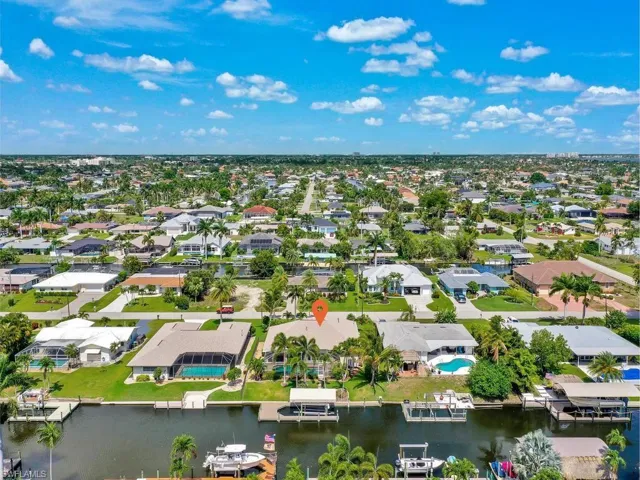 Waterfront property featuring a private boat dock, pool, and mature landscaping