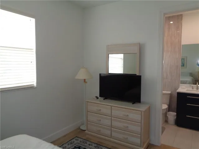Bedroom featuring ensuite bath and light wood-style floors