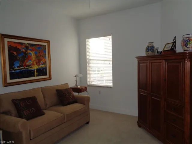 Living area featuring baseboards and light carpet