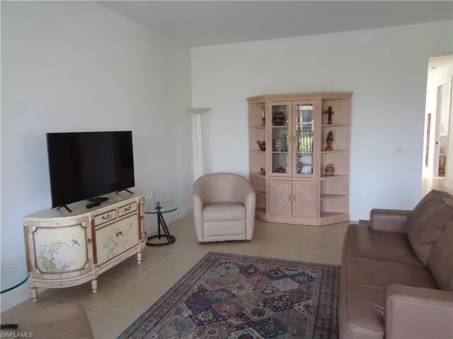Living room with light tile patterned flooring and baseboards