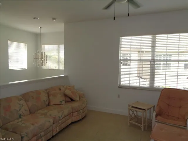 Living area featuring a chandelier, tile patterned floors, and ceiling fan