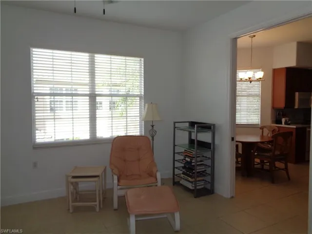 Living area with light tile patterned floors and a chandelier