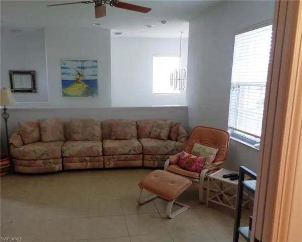 Living area featuring a ceiling fan and light tile patterned floors