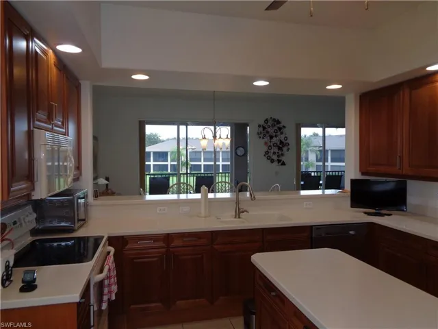 Kitchen featuring black appliances, a chandelier, recessed lighting, ceiling fan, and a peninsula