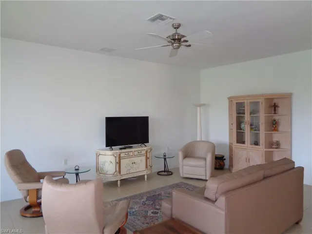 Living room with light tile patterned floors and ceiling fan