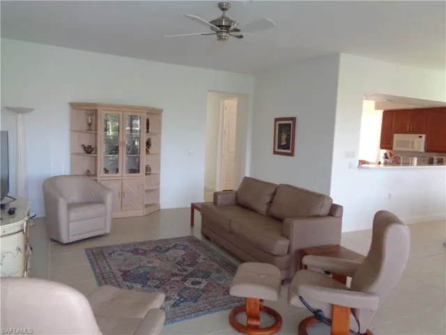 Living area with light tile patterned floors and ceiling fan